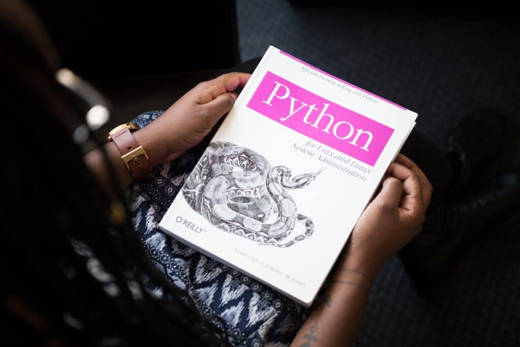 personne tenant un livre sur le lange Python entre les mains